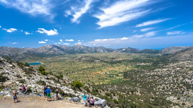 "Panoramic viewpoint over the Lasithi Plateau farmland with the sea visible in the distance"